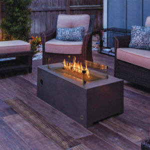 outdoor gas fire table with glass wall on back patio