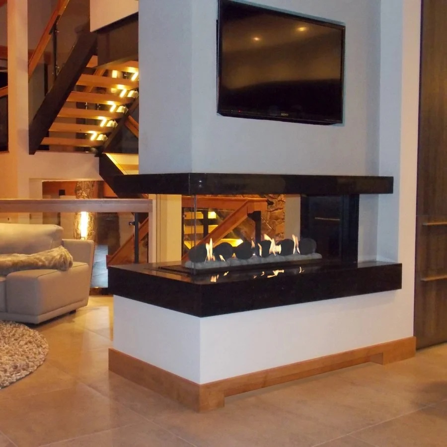 3 sided gas fireplace with round stone gas logs in modern living room